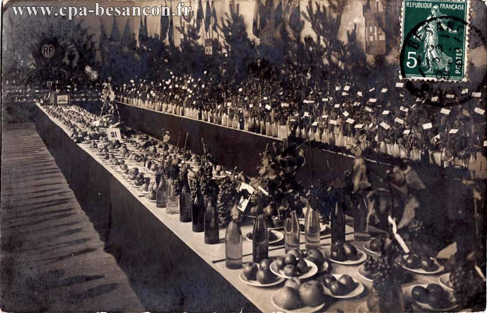 Exposition d'assiettes de fruits (pommes, raisin...) et de bouteilles